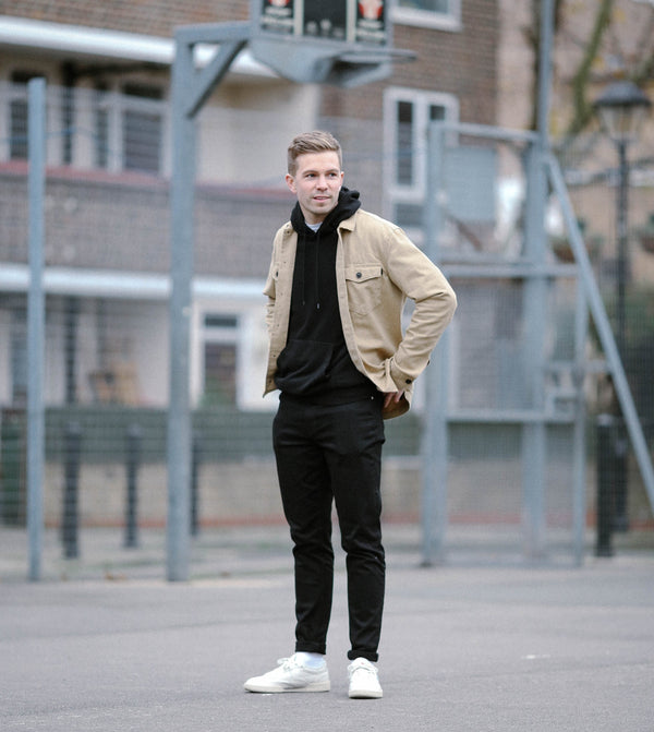 Man wearing pullover hoodie standing in a basketball court