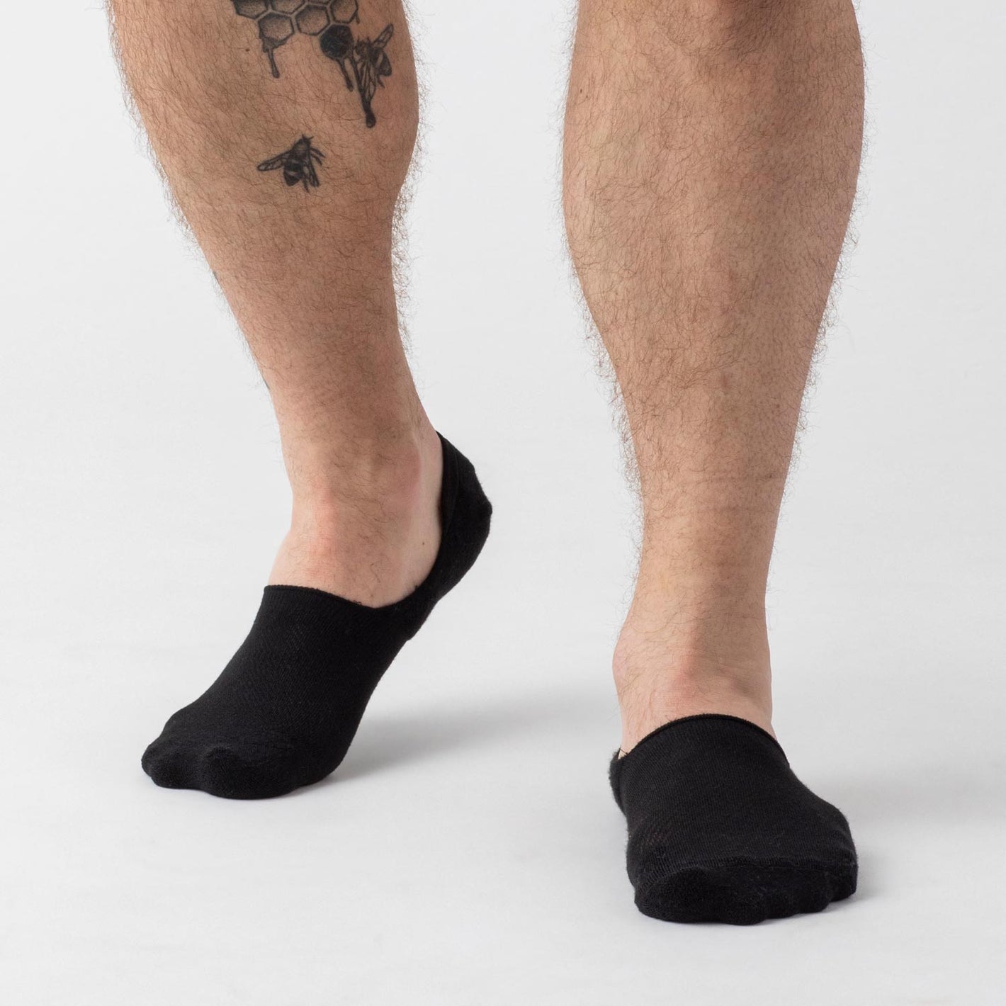 Black Never Show Socks 12-Pack on tattooed leg with bees.