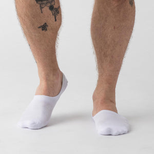True ClassicWhite Never Show Socks 6-Pack on tattooed calf, featuring seamless toe.