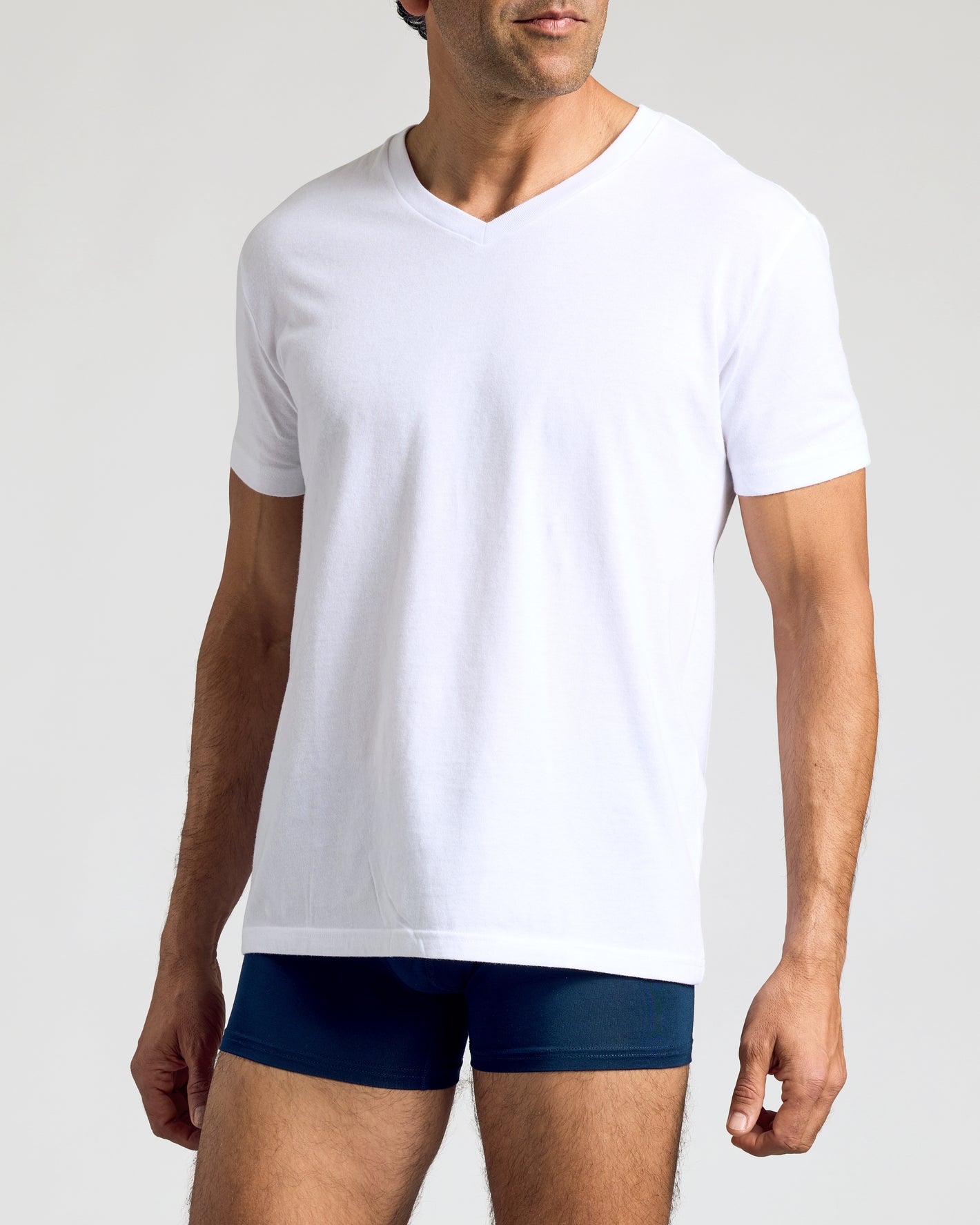 Male model wearing Navy Boxer Trunks 6-Pack with white V-neck T-shirt.