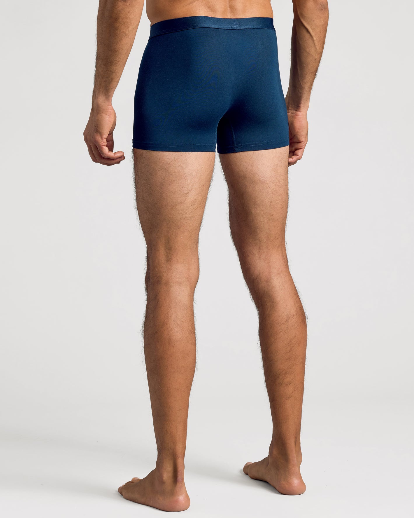 Man in snug Navy Boxer Trunks 12-Pack, showing rear fit.