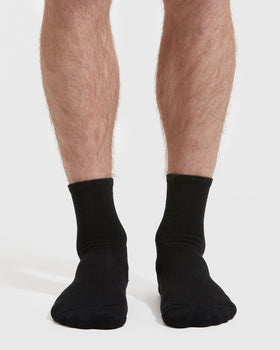 Black Half Crew Socks 3-Pack on legs against white background.