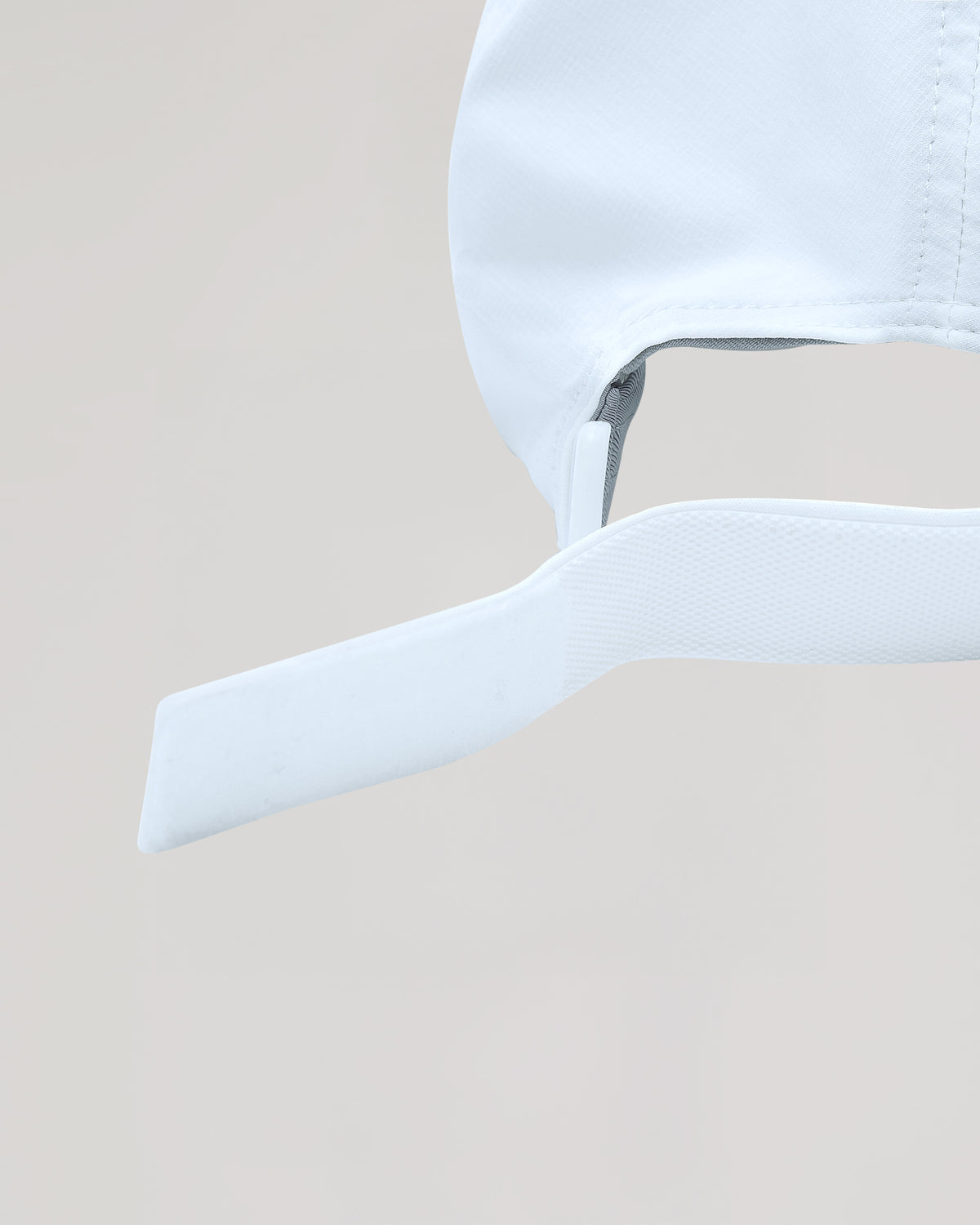 White Active Running Cap with adjustable Velcro strap, emphasizing its secure fit.
