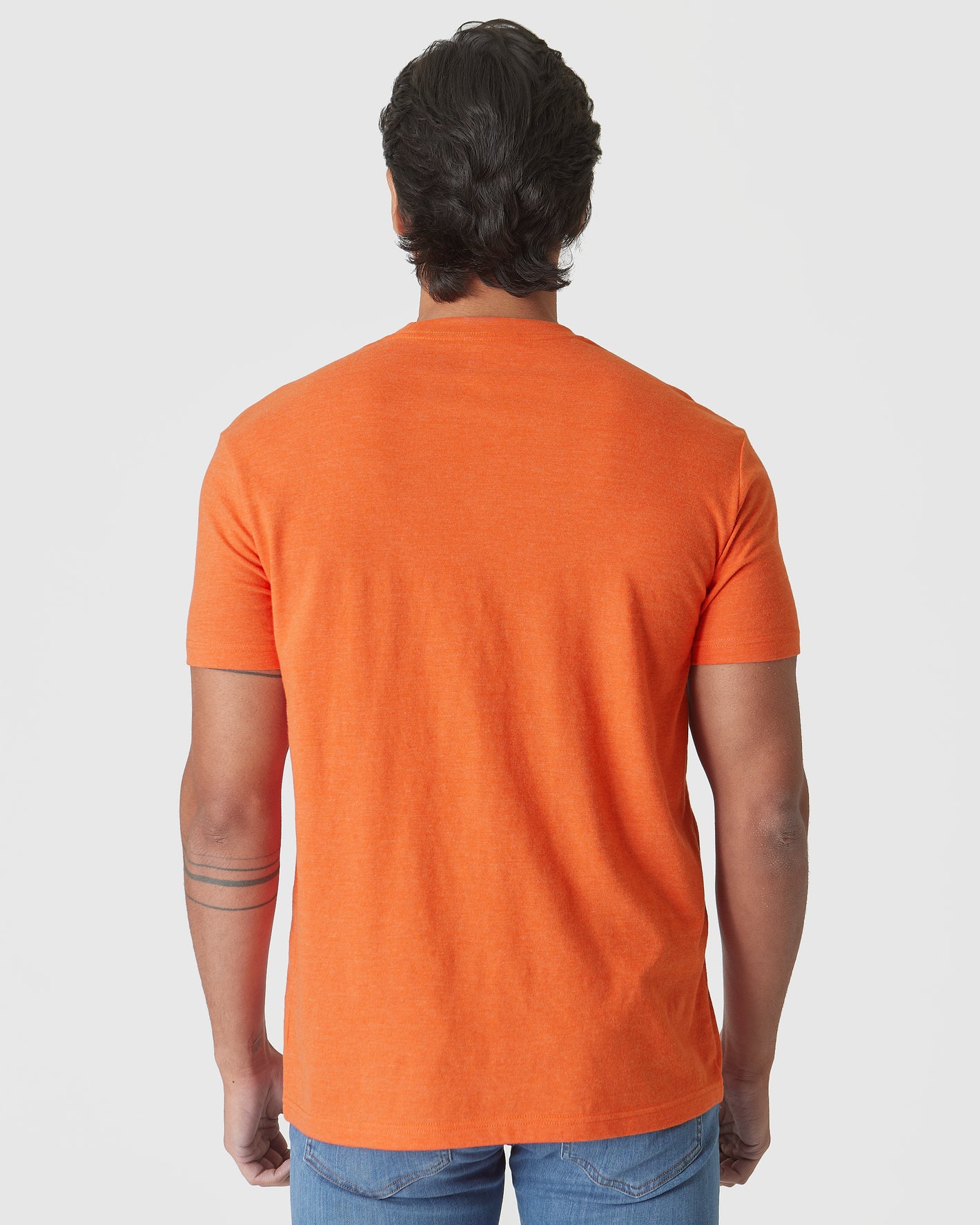 Man in Burnt Orange Heather Classic Crew Neck and jeans, back view.
