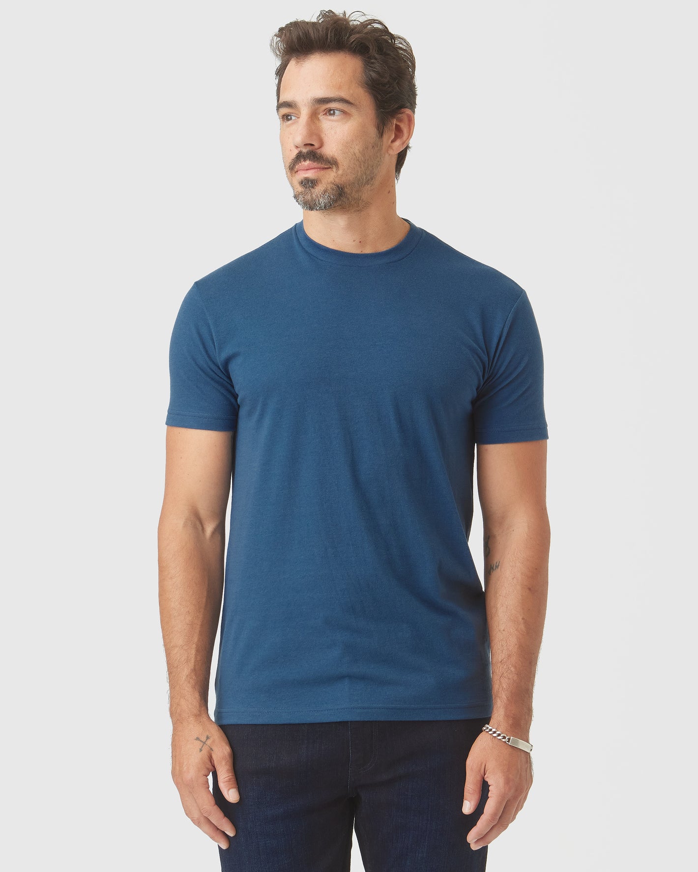 Man wearing Deep Sea Blue Classic Crew Neck, plain blue tee, relaxed fit.