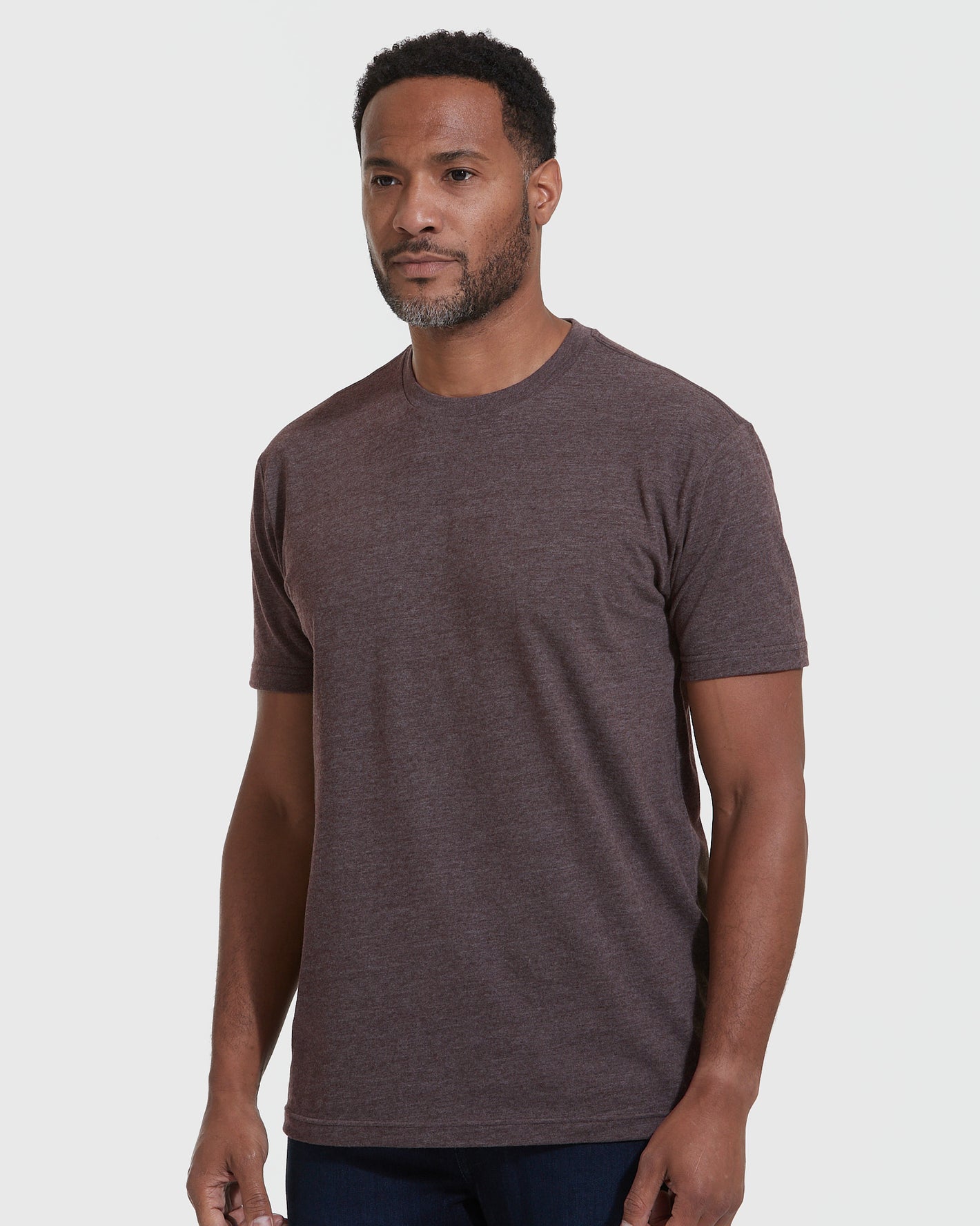 Man wearing Heather Dark Oak Crew Neck T Shirt and dark jeans.