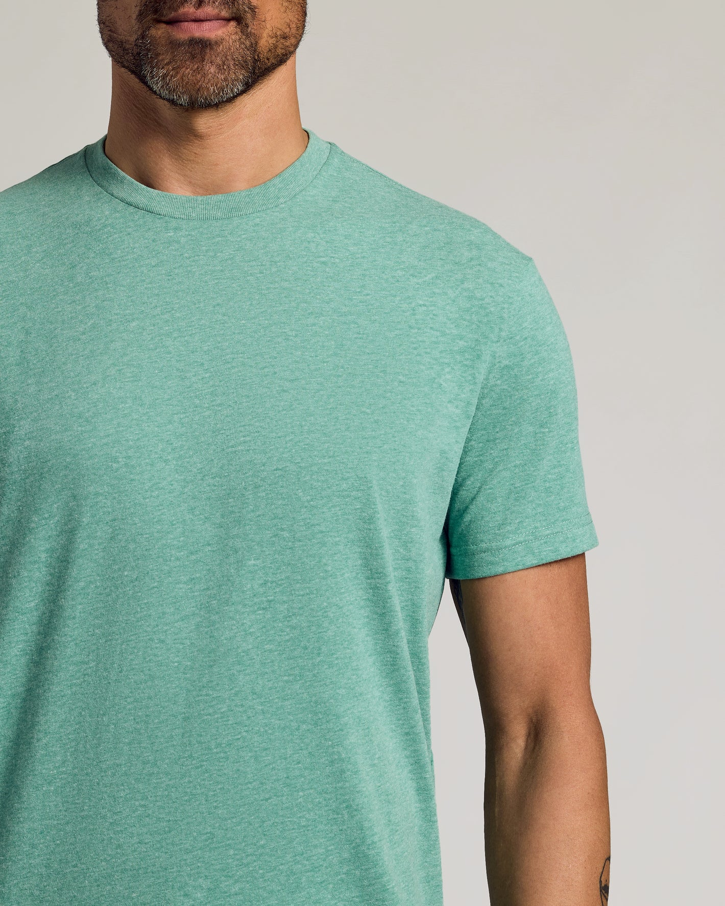 Light Heather Greenery Classic Crew Neck on model, showcasing fit and tattoo detail.