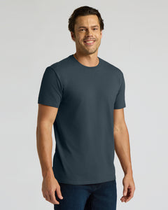 True ClassicA man wearing a dark slate blue crewneck t-shirt and dark blue jeans, standing against a light gray studio background.