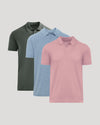 Three short-sleeve polo shirts shown in a layered arrangement on a light gray background: one dark olive green, one light blue, and one pink in front.