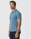 Man wearing Blue Lake Heather Classic Polo and dark jeans.