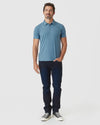 Man wearing Blue Lake Heather Classic Polo with dark jeans.