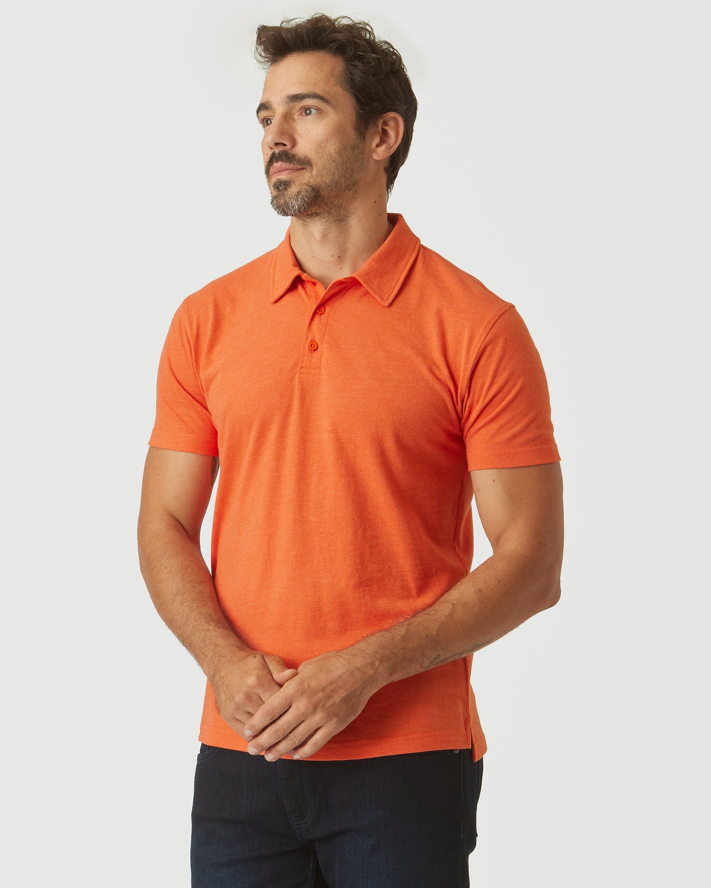 Man models Burnt Orange Heather Classic Polo, showcasing its fitted, athletic cut.