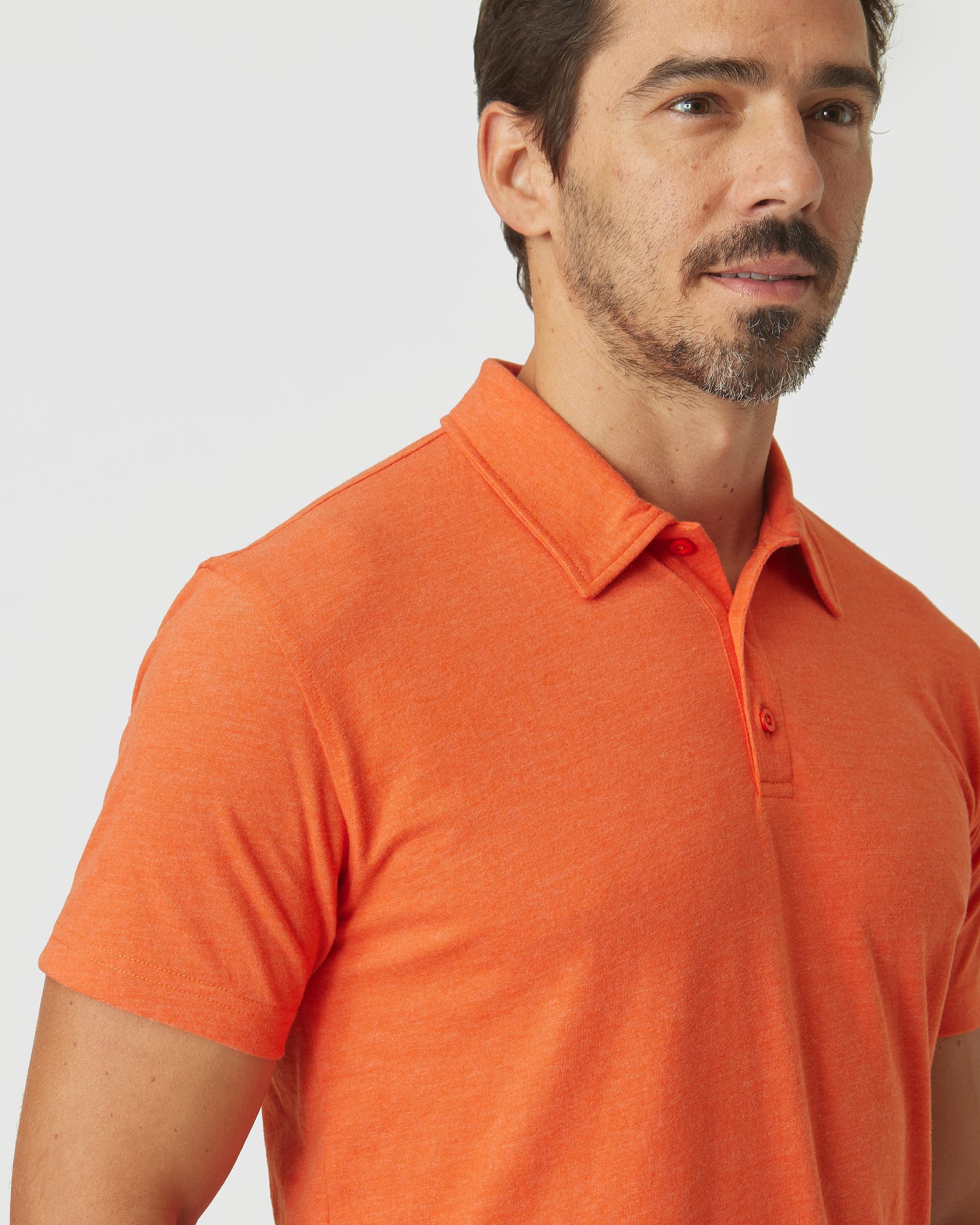 Man wearing Burnt Orange Heather Classic Polo with collar and buttons.