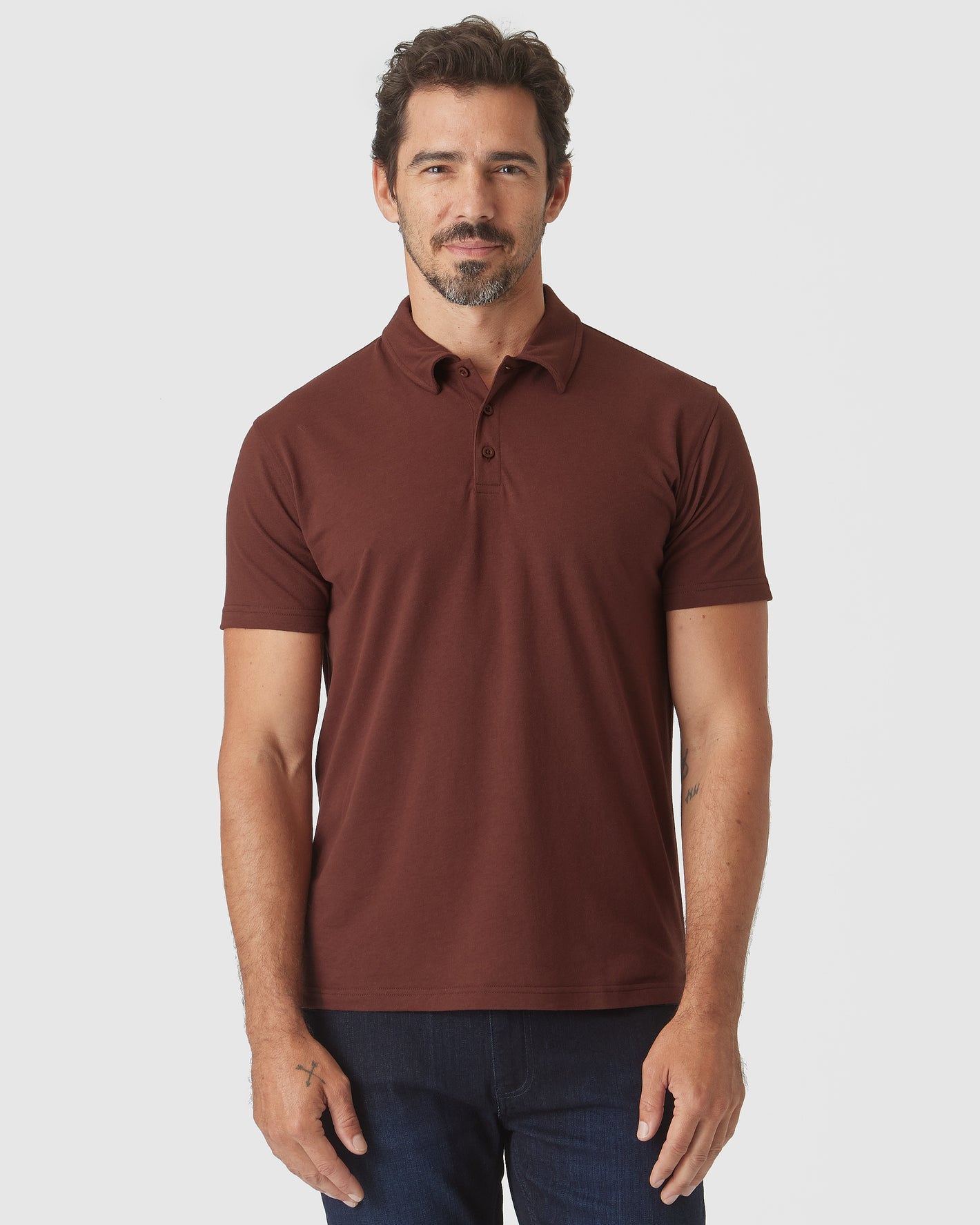 Man wearing Dark Chocolate Classic Polo with jeans, standing relaxed.