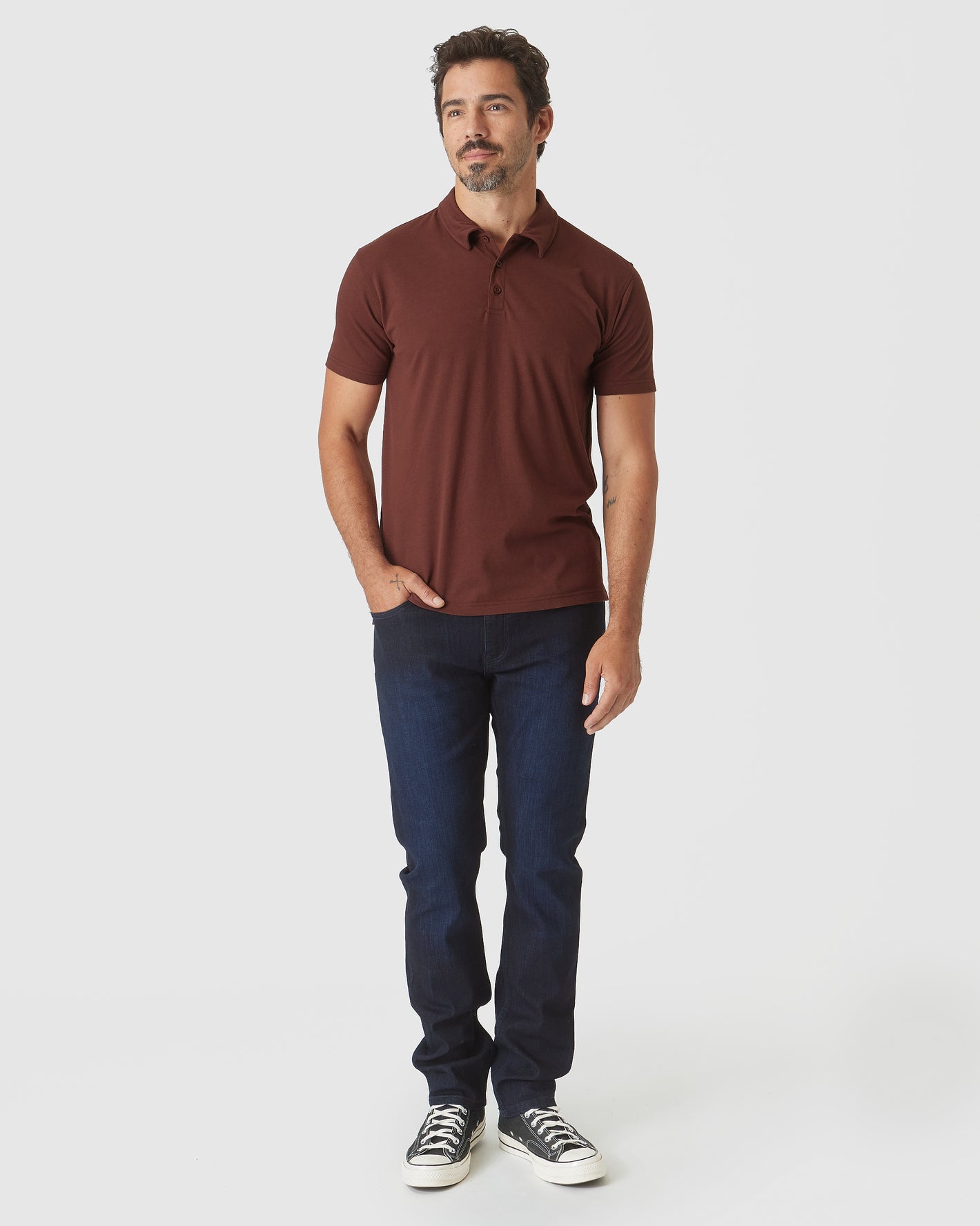 Man wearing Dark Chocolate Classic Polo and dark-wash jeans.