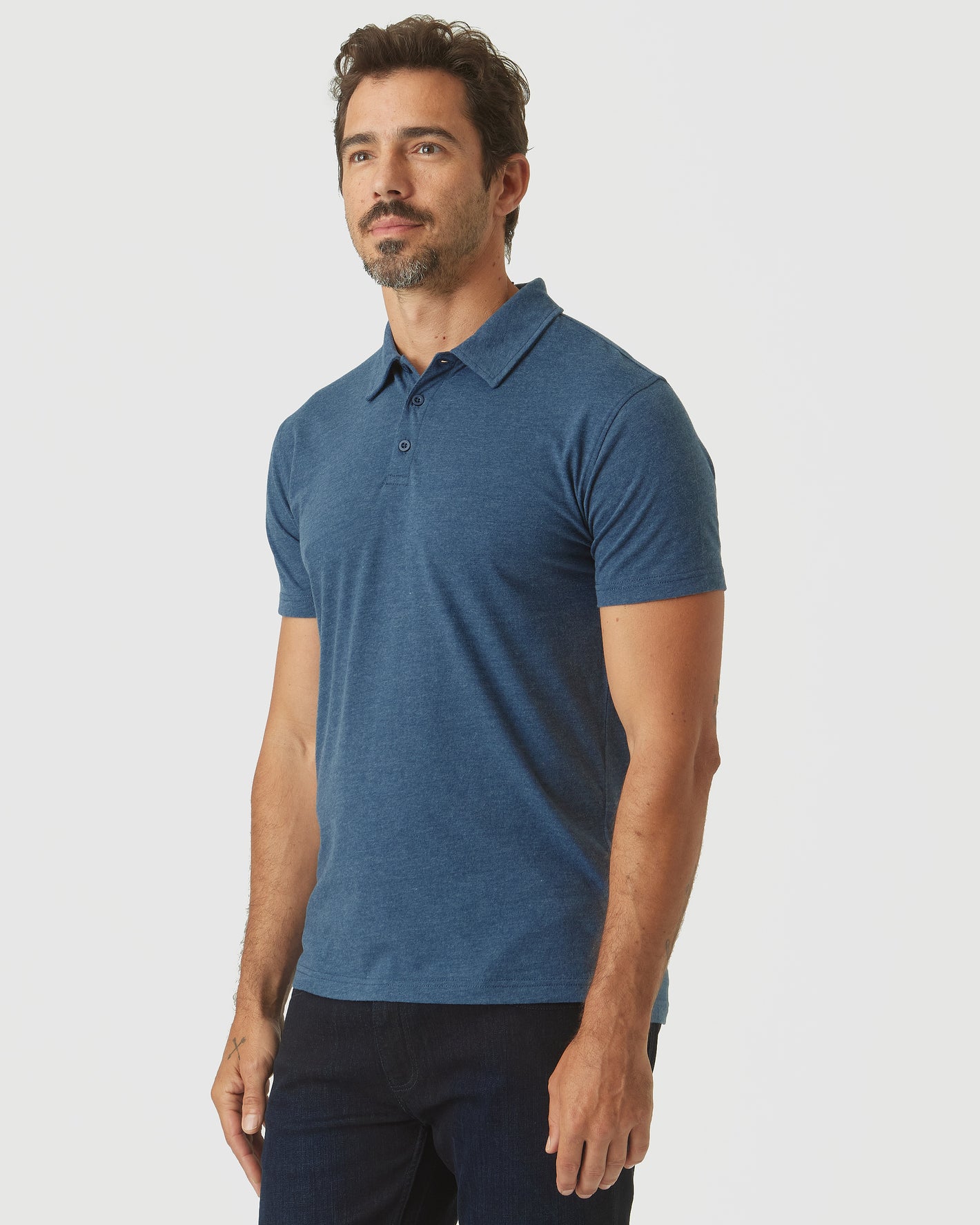 Man wearing Deep Sea Blue Heather Classic Polo, relaxed pose.