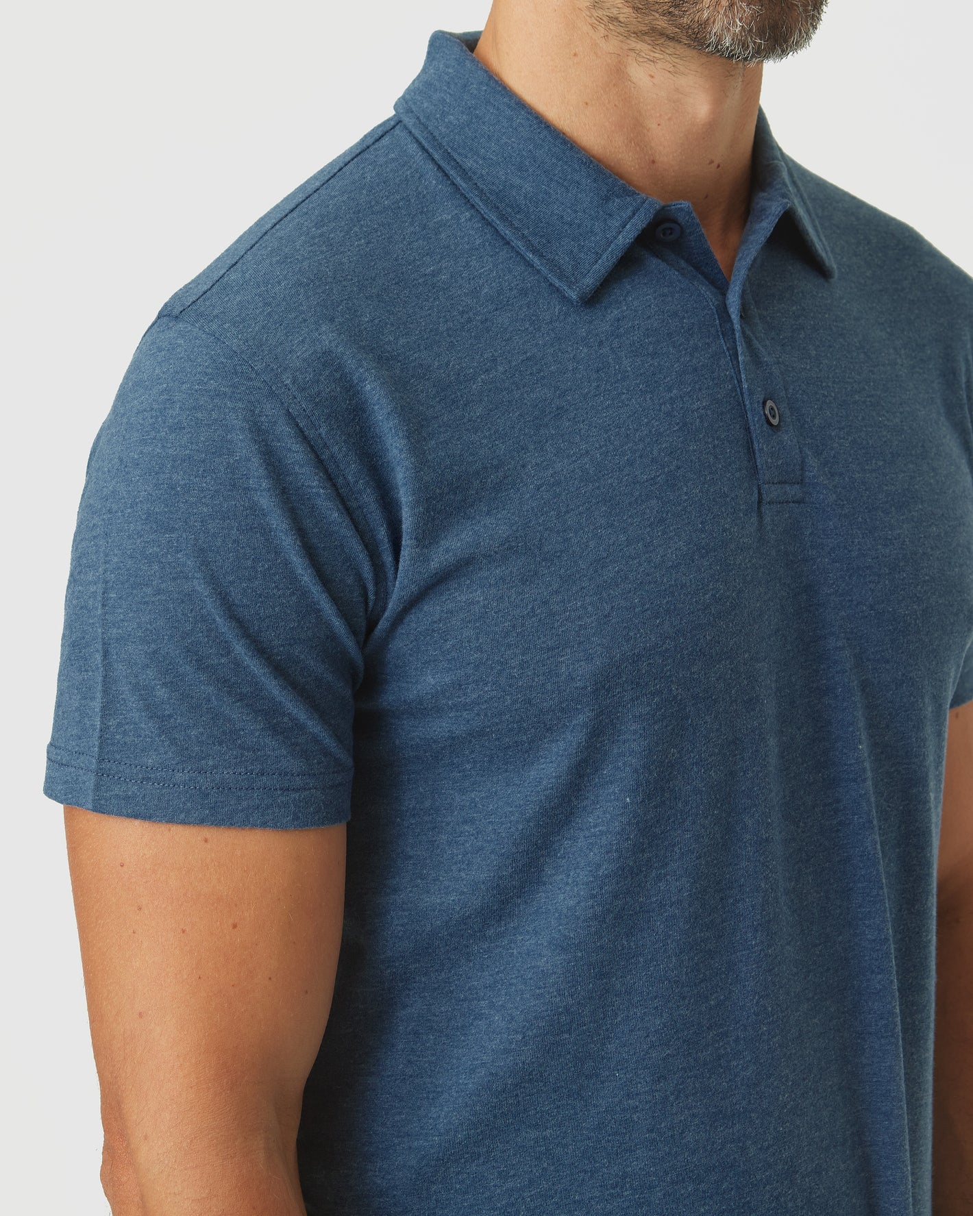 Deep Sea Blue Heather Classic Polo on male torso, short sleeves, fold-over collar.