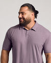 Man wearing Dark Heather Amethyst Short Sleeve Polo, smiling casually.