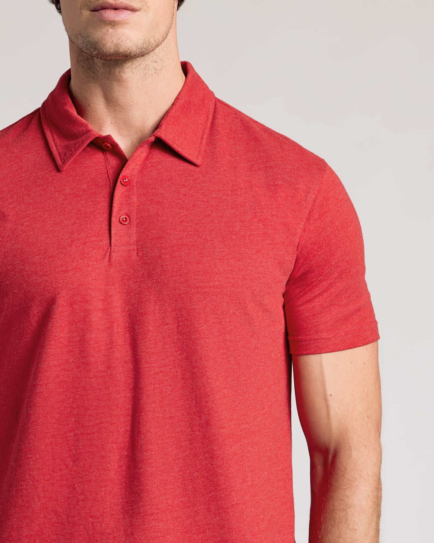 Man wearing Dark Heather Lava Short Sleeve Polo, showcasing its two-button placket.