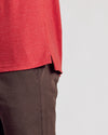 Dark Heather Lava Short Sleeve Polo hem and side slit over brown pants.
