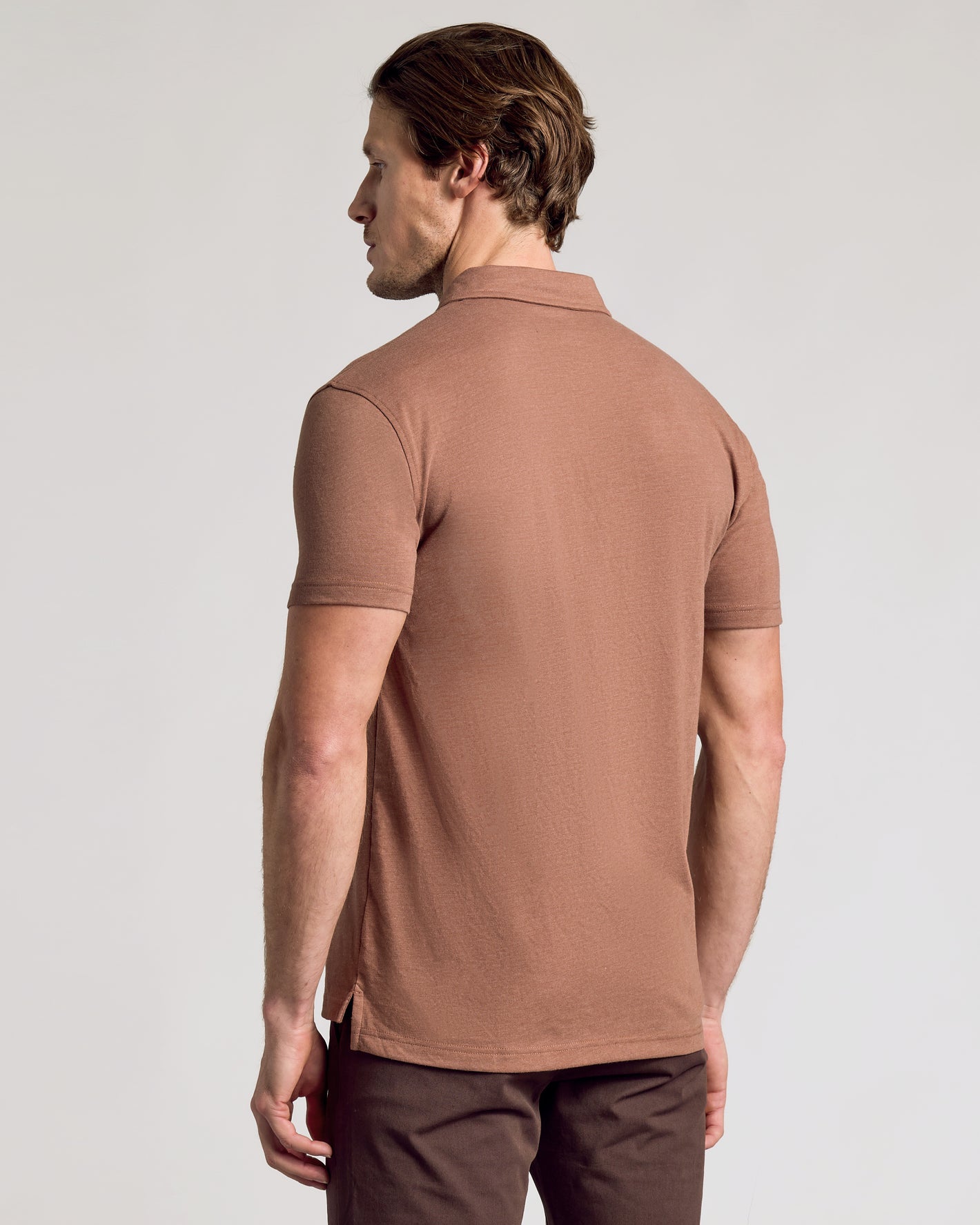 Man wearing Dark Heather Sepia Classic Polo, side profile view.