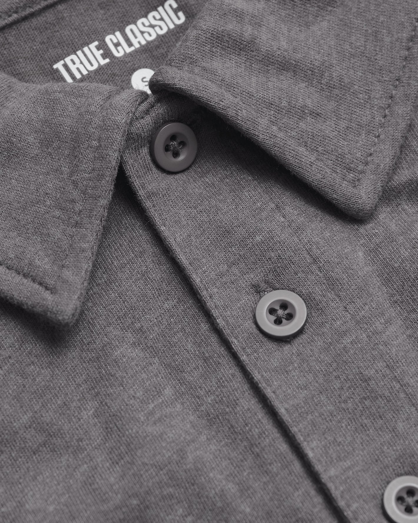 Heather Graphite Short Sleeve Polo with collar, buttons, and “TRUE CLASSIC” label visible.