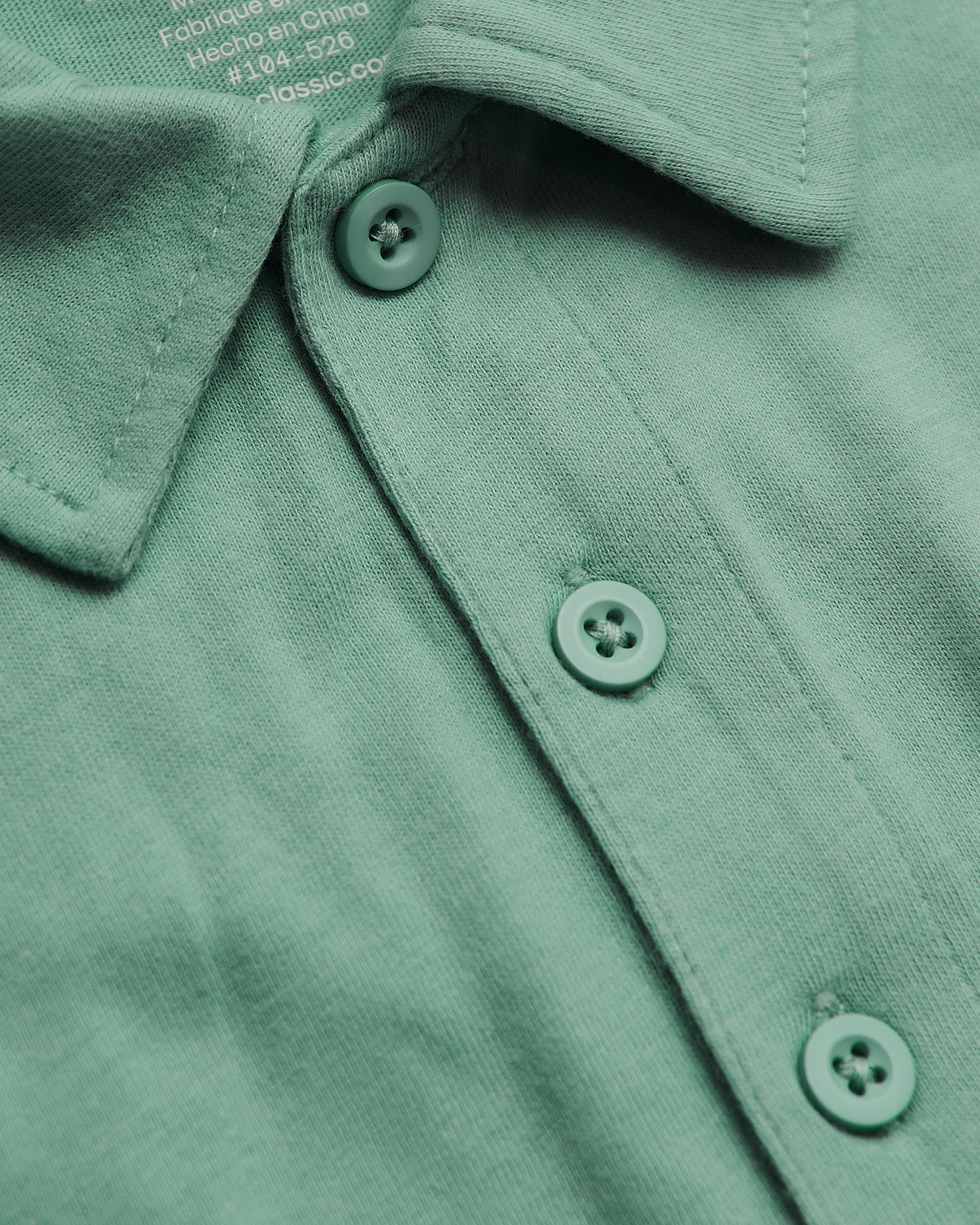 Light Heather Greenery Classic Polo with three-button placket and soft tag.