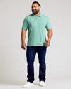 Man wearing Light Heather Greenery Classic Polo, dark jeans, white sneakers.