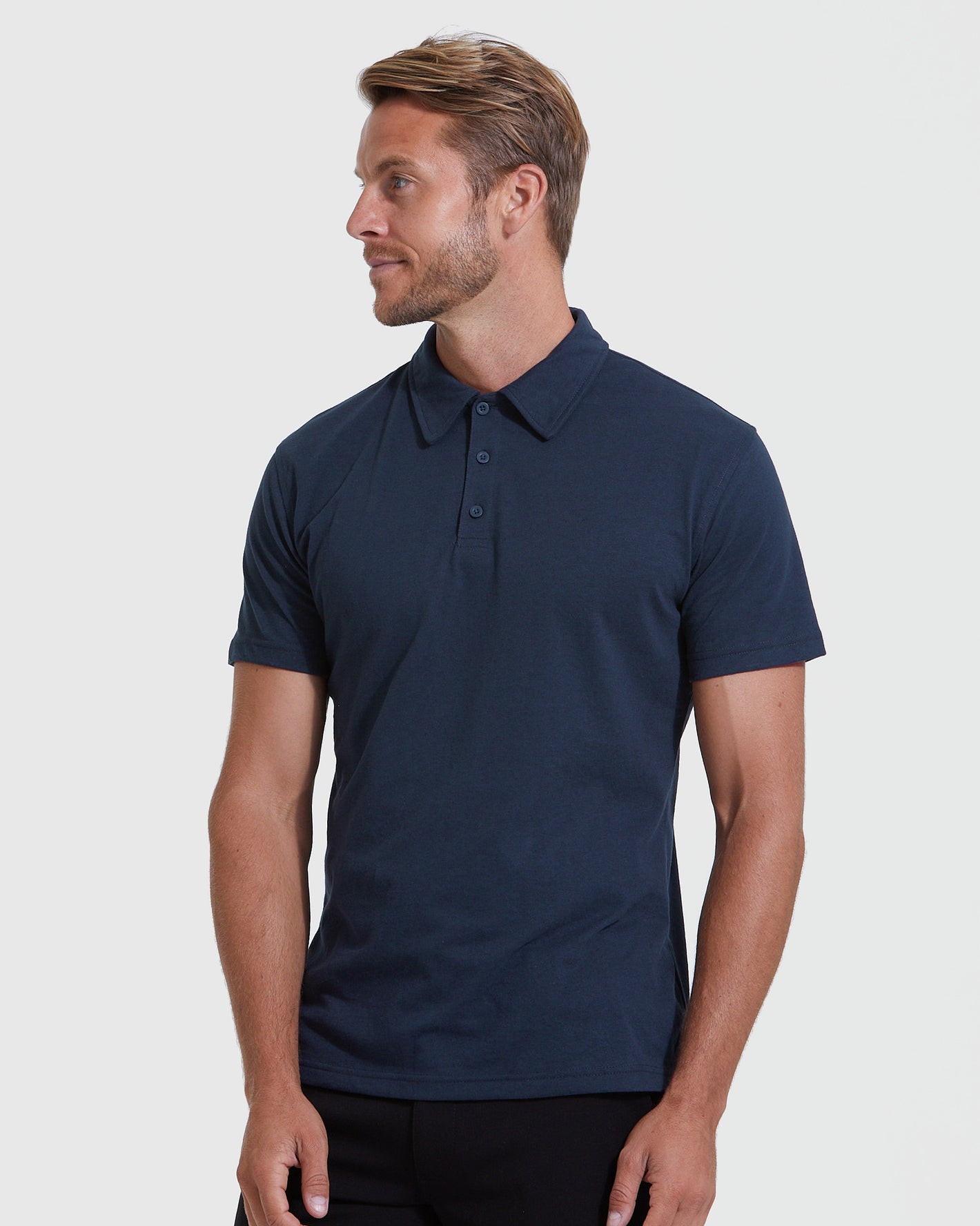 Model in All Navy Short Sleeve Polo 6-Pack, relaxed pose.