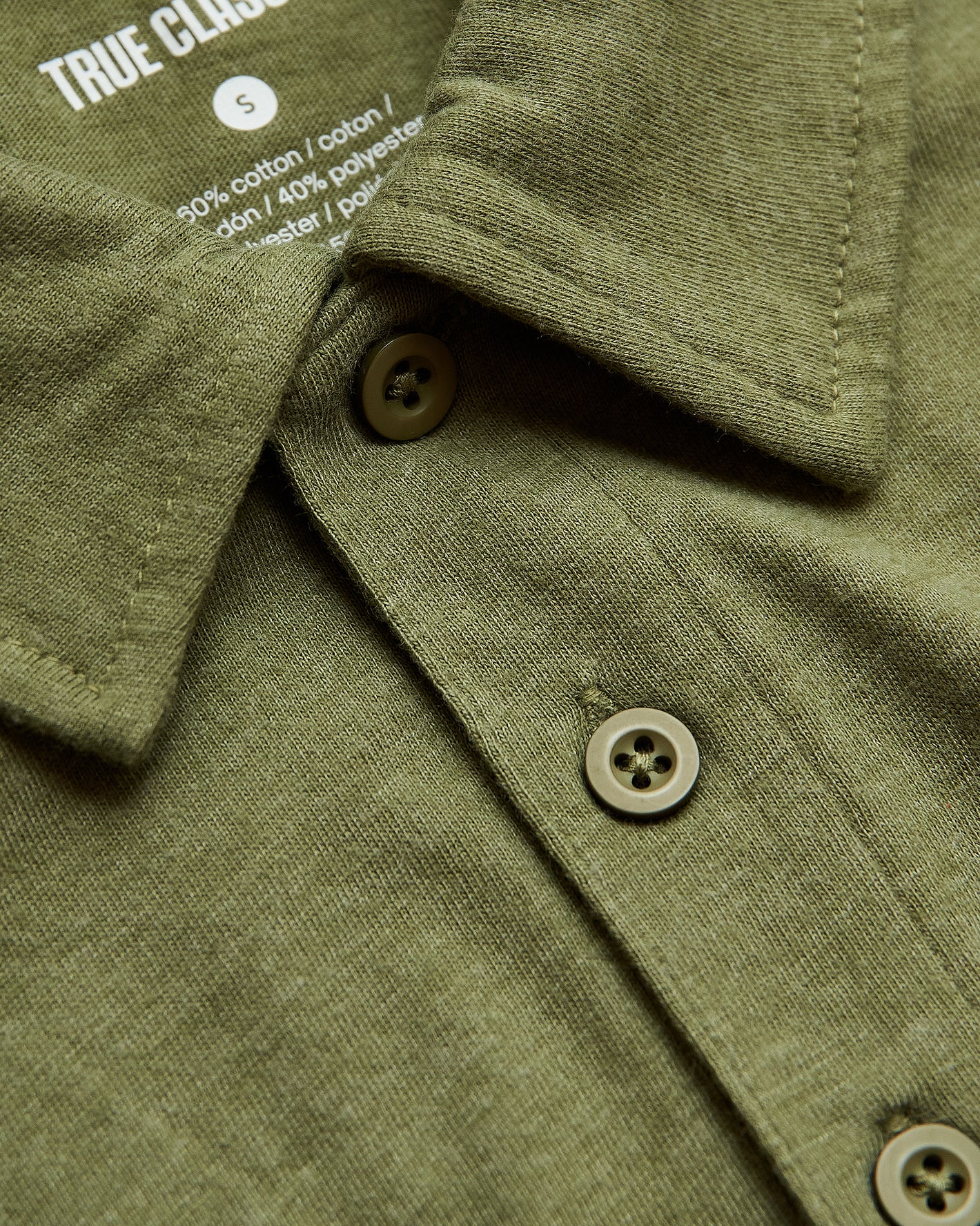 Olive Green Heather Polo with button placket and soft tag.