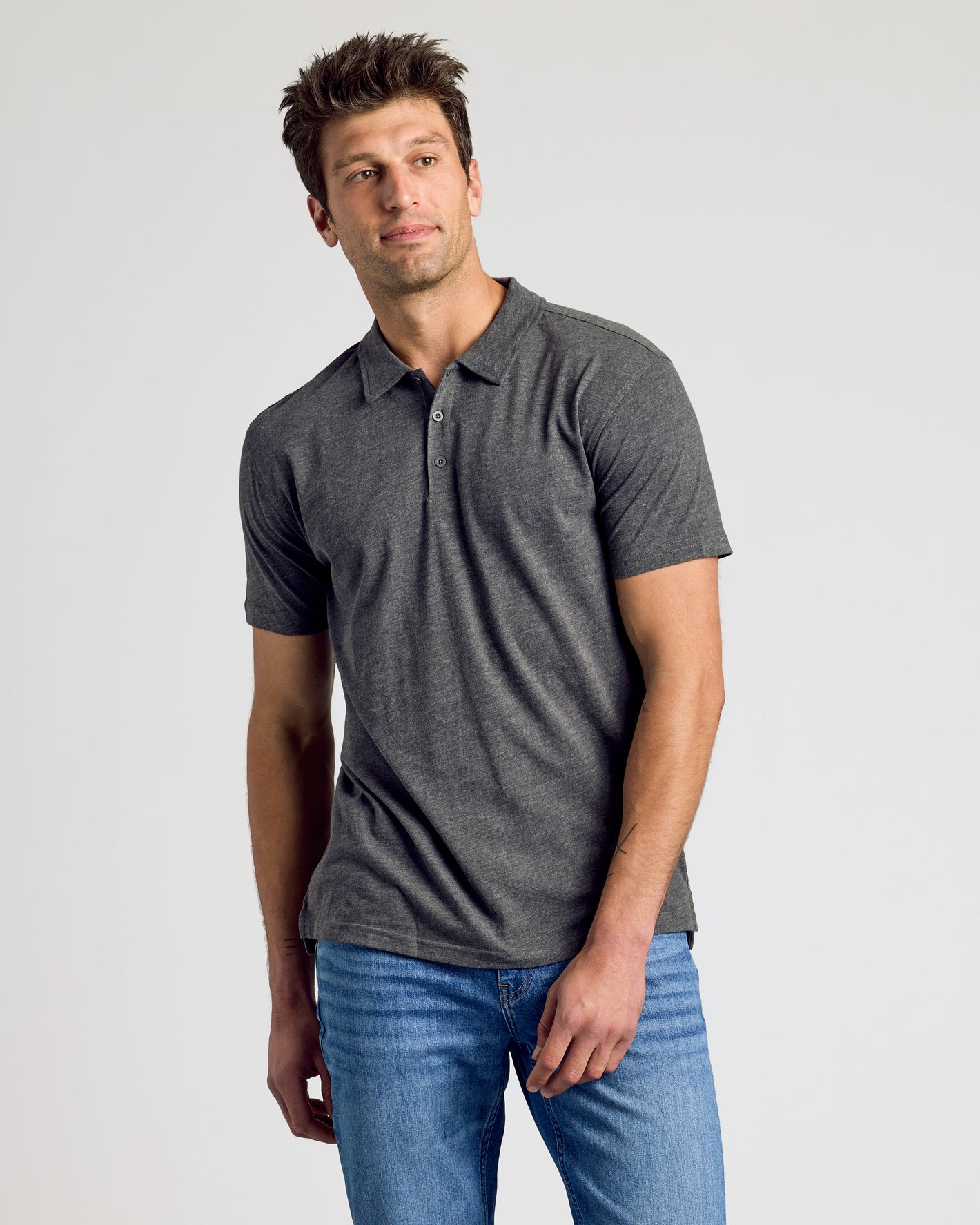Man wearing Heather Polo 3-Pack in charcoal-gray with blue jeans.