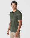 Young man models Racing Green Heather Polo with tan trousers.