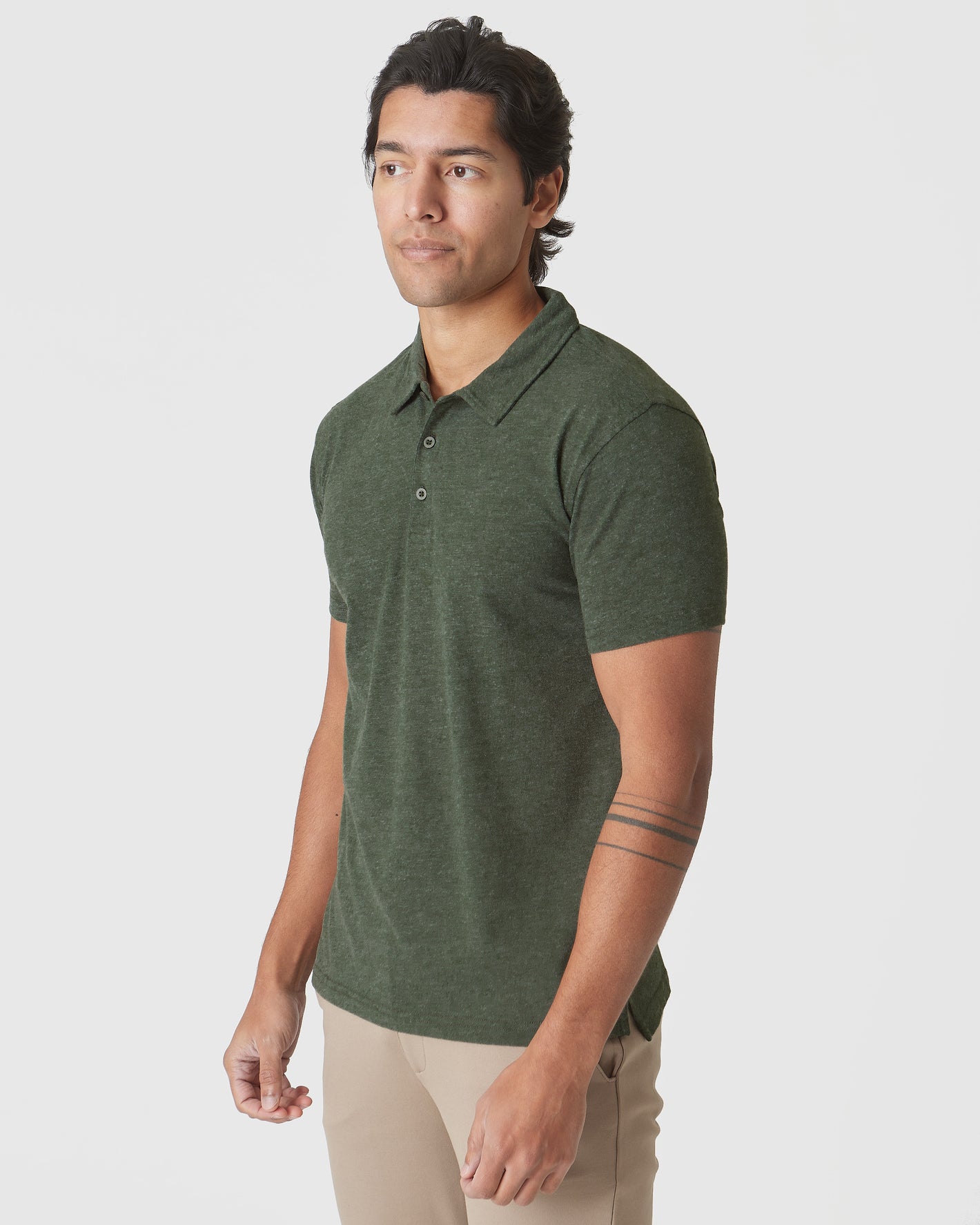 Young man models Racing Green Heather Polo with tan trousers.