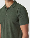 Person wearing Racing Green Heather Polo with collar and tattooed forearm visible.