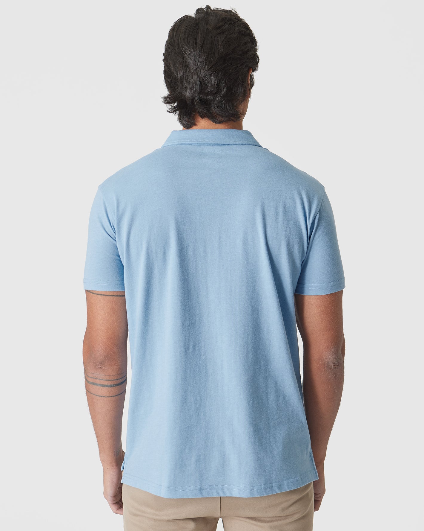 Sky Blue Heather Polo, back view, worn with tan pants.