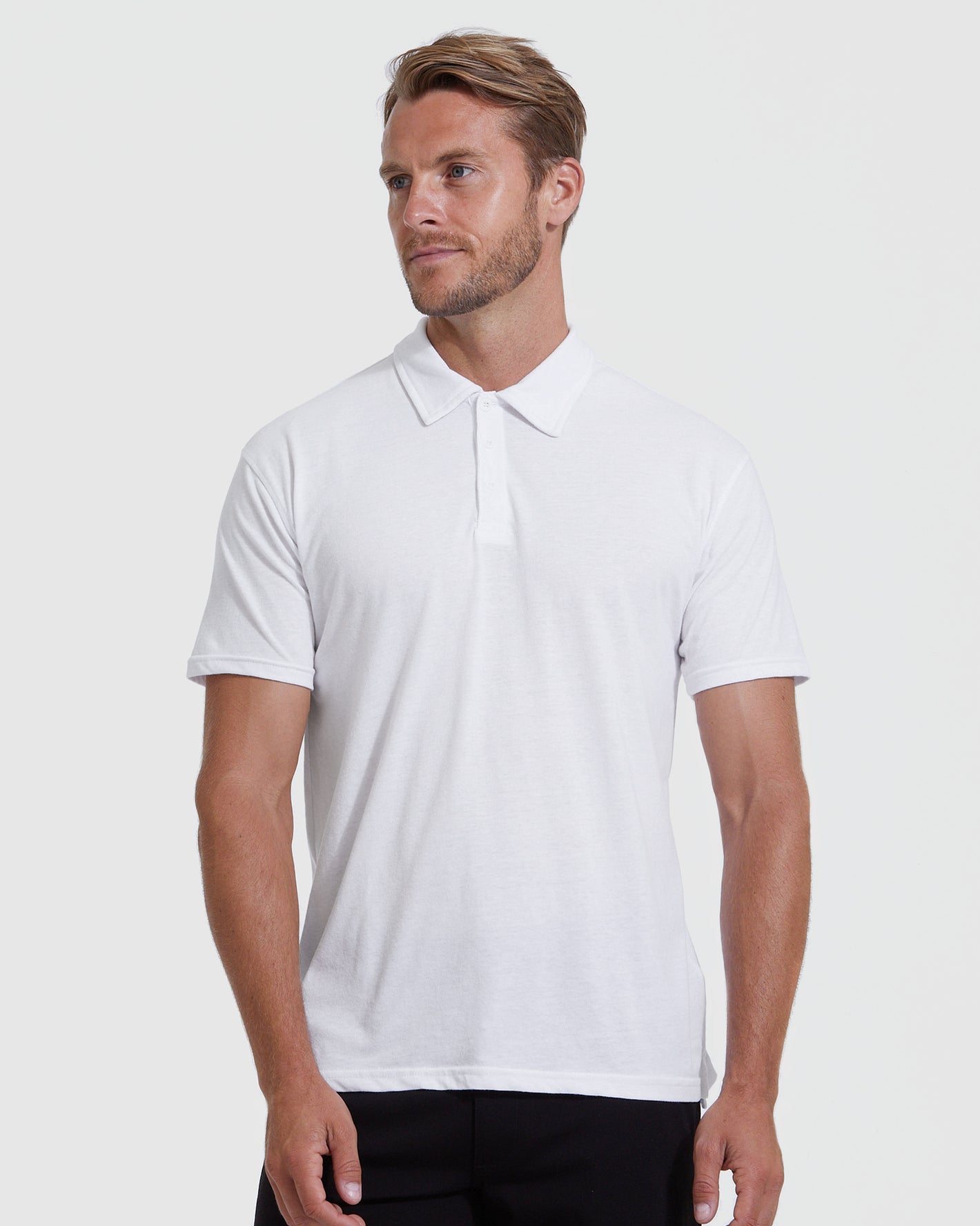 Male model in White Classic Polo 3-Pack, short-sleeve, three-button placket.