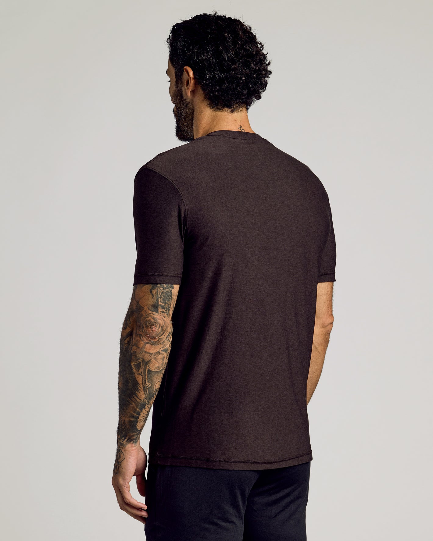 Man wearing Dark Heather Cocoa Active Crew Neck Tee, showcasing tattooed arm.