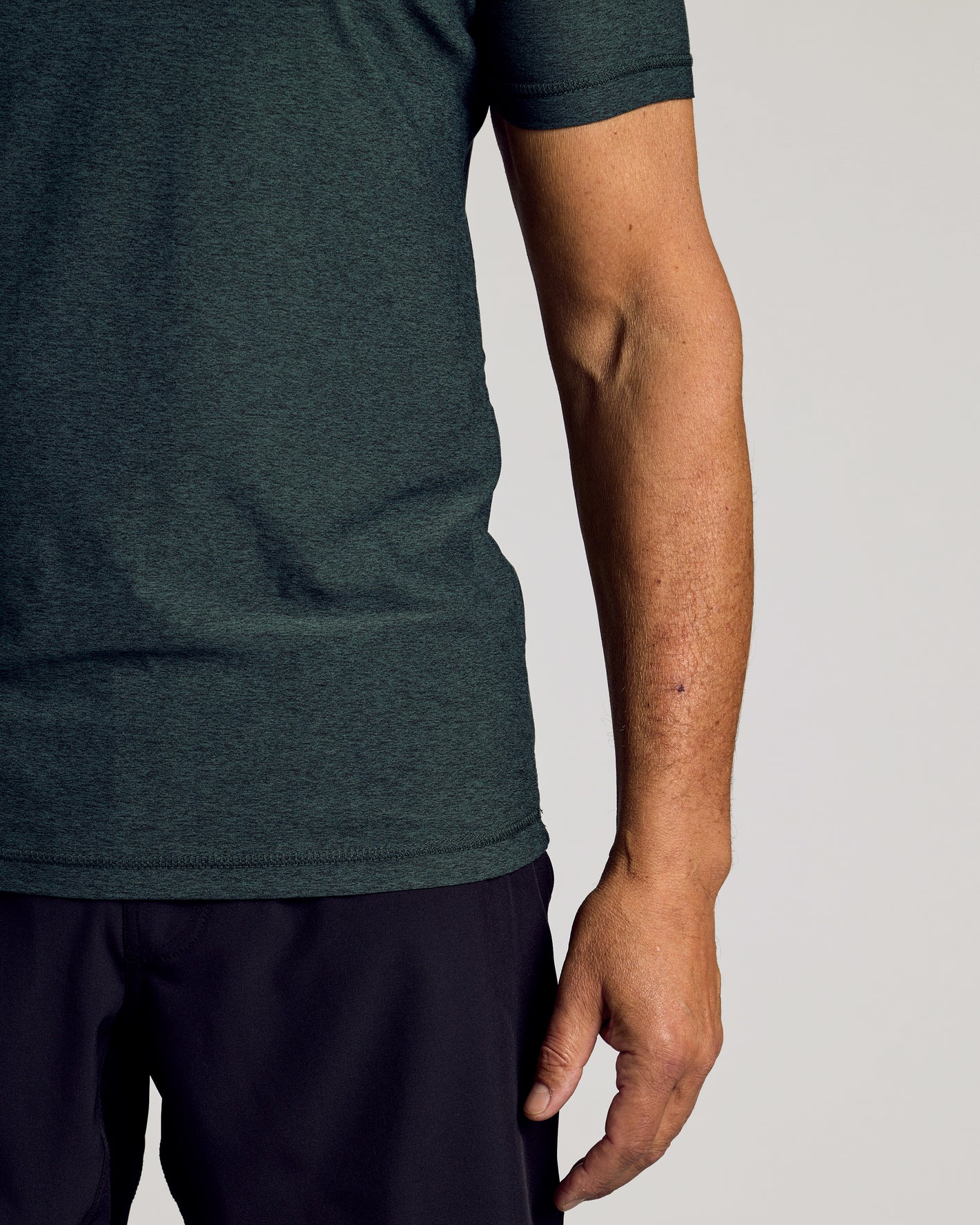 Dark Heather Forest Active Short Sleeve Crew Neck Tee worn with black bottoms.