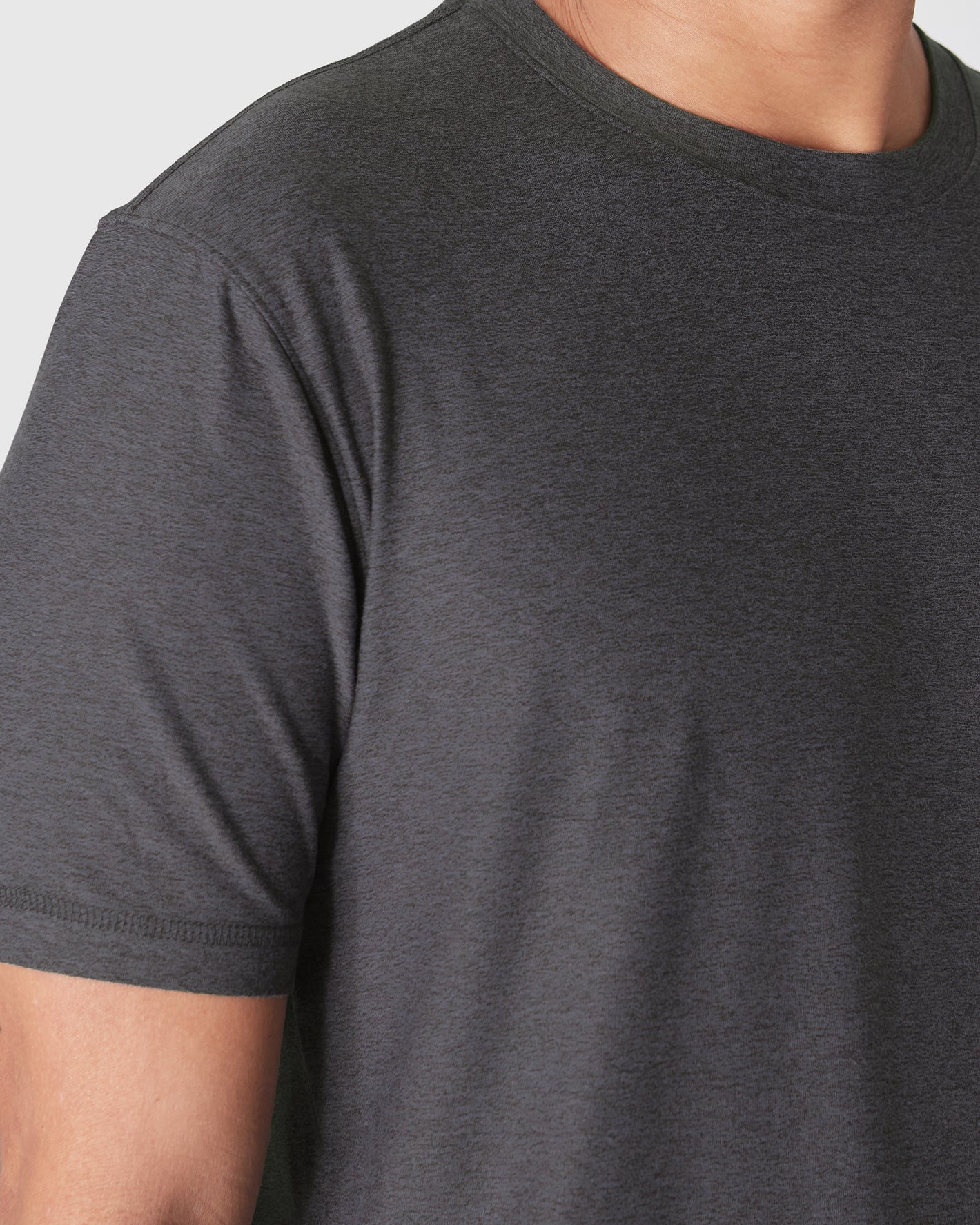 Dark Heather Tempest Active Crew Neck Tee on upper torso, showcasing fabric texture.