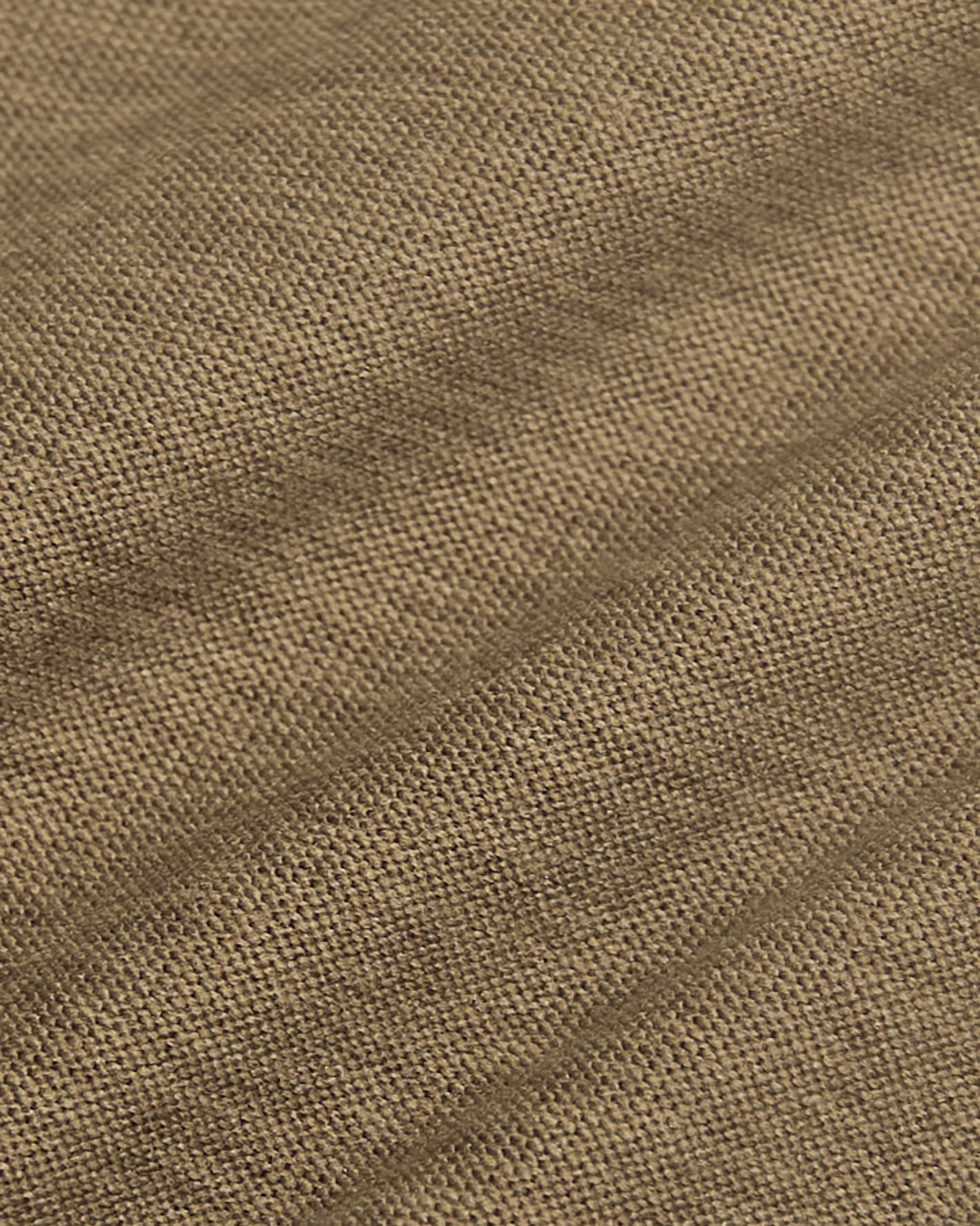 A close-up of a woven fabric texture in a warm taupe-brown color, showing the detailed knit pattern and subtle diagonal folds.