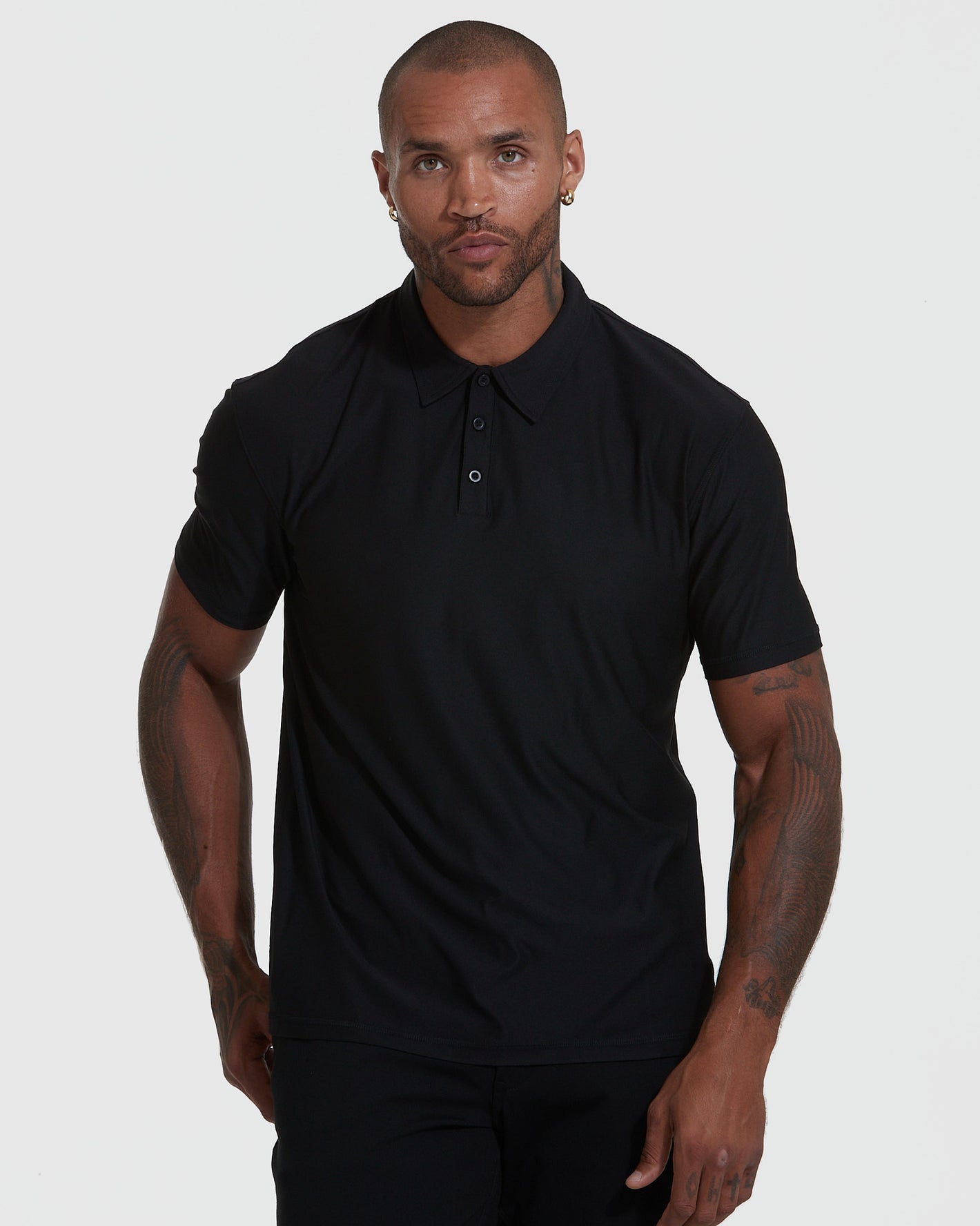 Man wearing Active Short Sleeve Polo, showcasing fit and tattoos.
