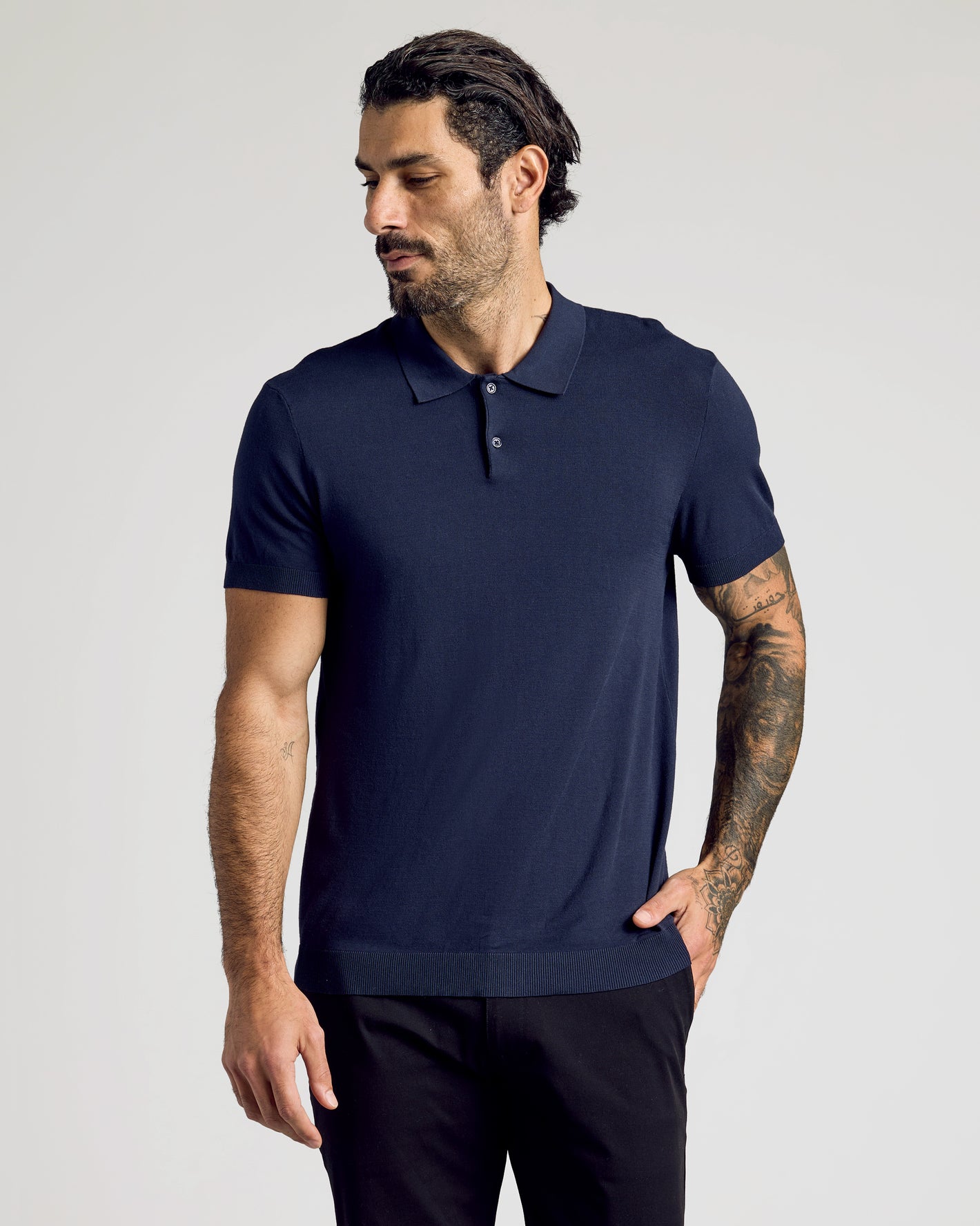 Man wearing Navy Short Sleeve Sweater Polo with tattoos visible on forearm.