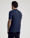 Man in Navy Short Sleeve Sweater Polo with tattooed arm.
