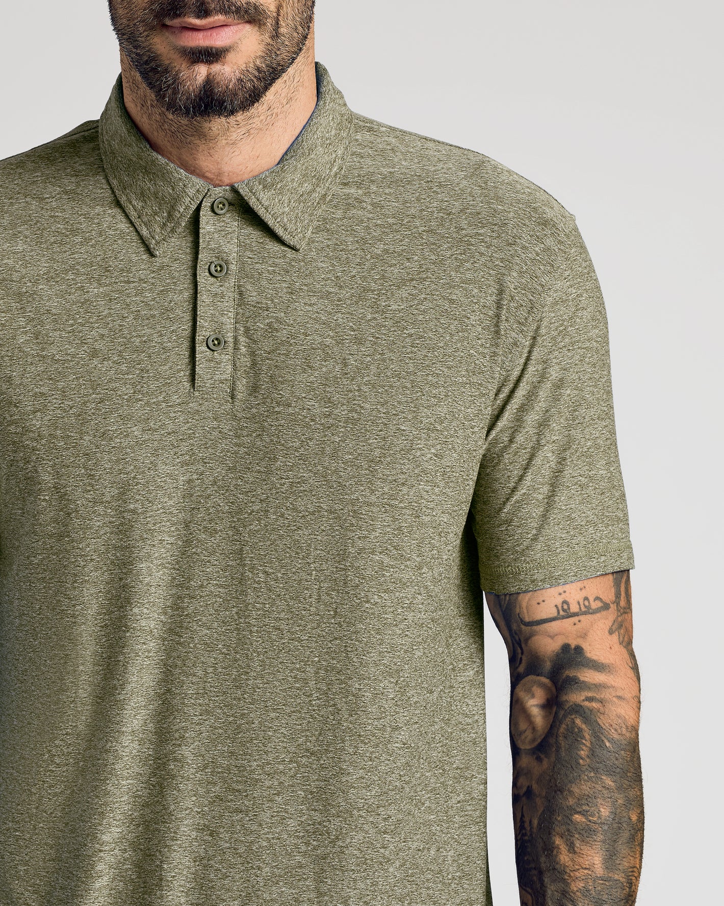 Man wearing a green polo shirt with a plain background