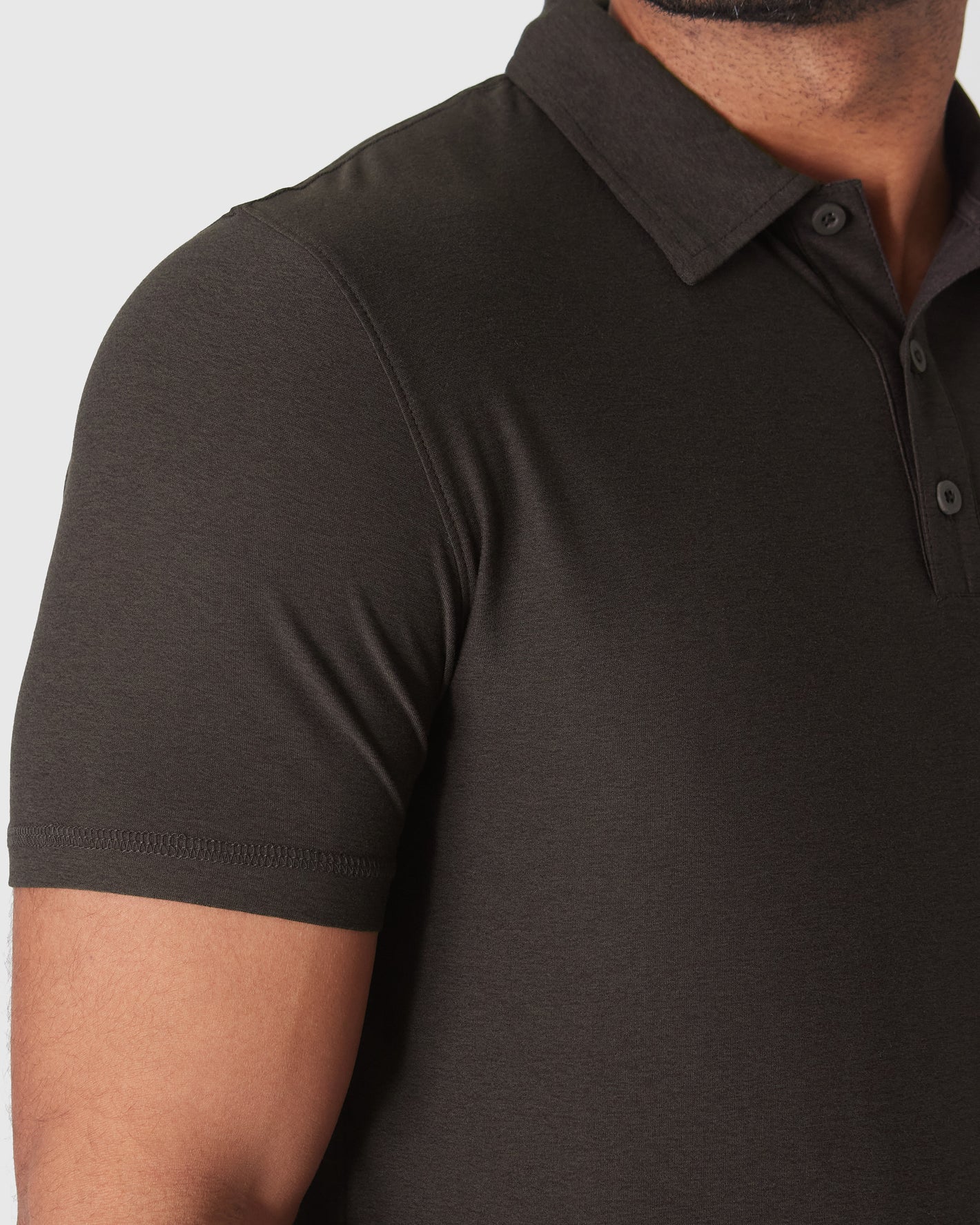 Man wearing Dark Heather Cocoa Active Polo 2.0, showcasing its fitted style.