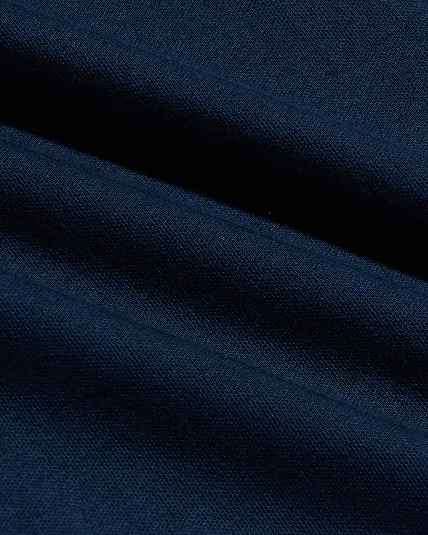 Close-up of soft navy fabric texture highlighting the quality material used in the Navy Pima Cotton Blend Curved Hem Crew, a men's basic essential for comfort and style.