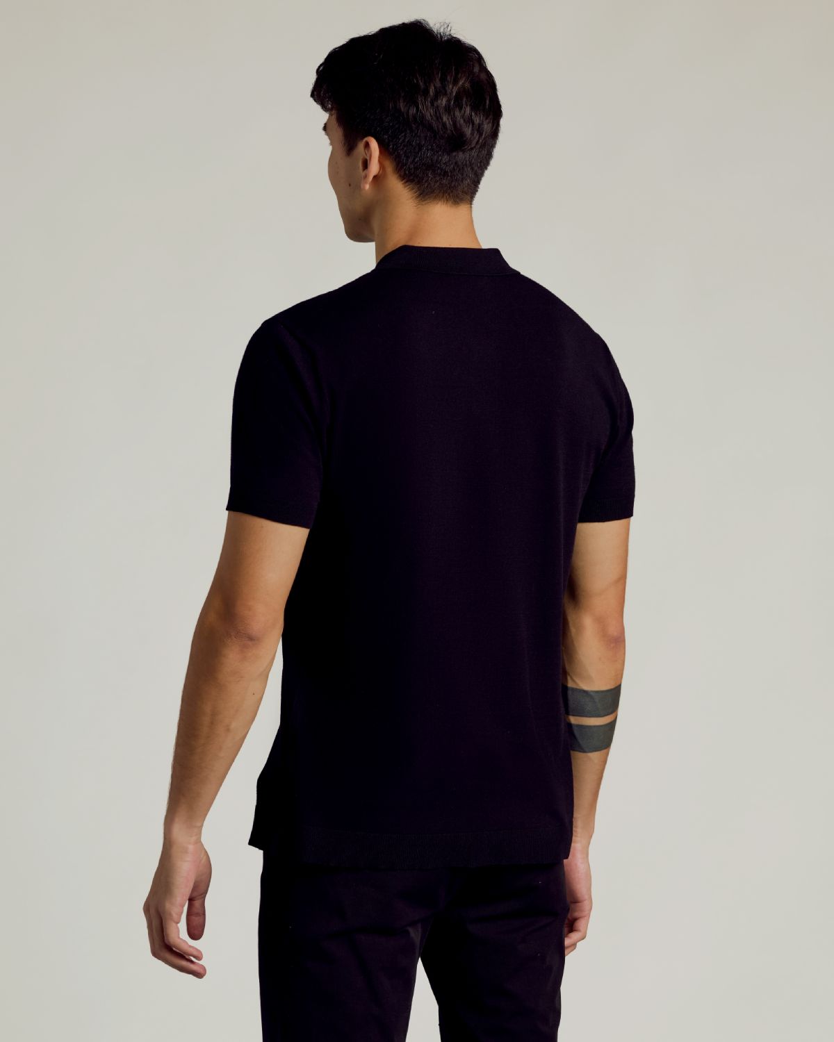 Back view of man in All Black Dressy Polo.