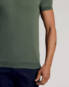 Moss Dressy Polo on a person, showing fit and forearm tattoos.