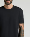 Close-up of a man wearing an all-black crew neck t-shirt from the All Black Pima Cotton Blend Crew 7-Pack, showcasing a smooth, comfortable fabric ideal for men's basics.