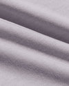 A close-up of draped light gray knit fabric with a fine ribbed texture and soft folds.